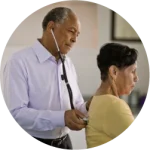 General practitioner checking woman's heart rate