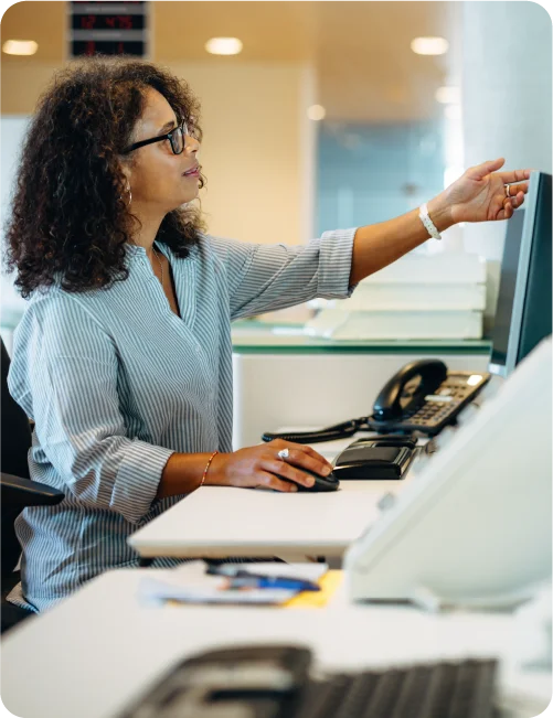 Woman with a cloud healthcare phone system working at front desk in a hospital