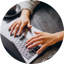 Laptop being used at a wooden desk by a primary care worker